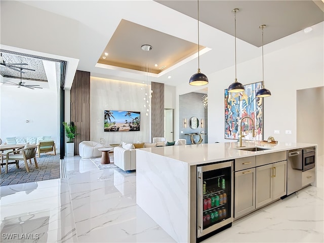 kitchen with wine cooler, a tray ceiling, sink, hanging light fixtures, and ceiling fan