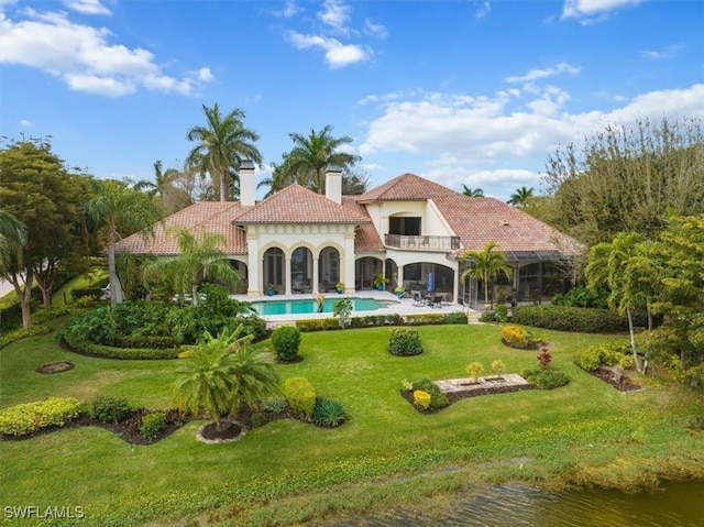 back of house featuring a lawn and a balcony