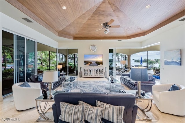 living room with ceiling fan, wooden ceiling, a healthy amount of sunlight, and a raised ceiling