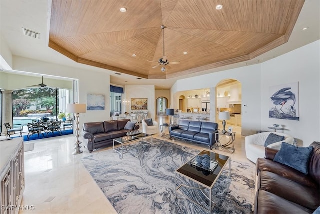 living room featuring a tray ceiling, wood ceiling, and ceiling fan