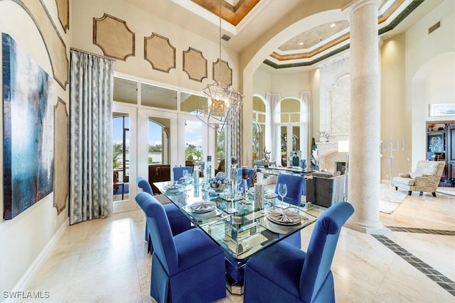 tiled dining room featuring a high ceiling, french doors, ornate columns, and crown molding