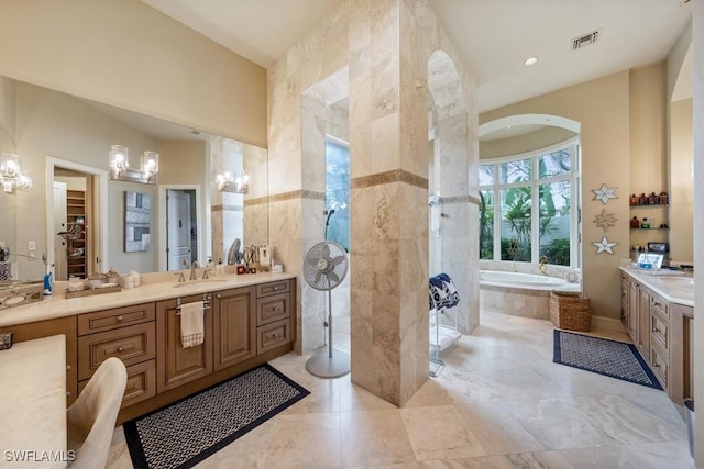 bathroom with vanity and tiled bath