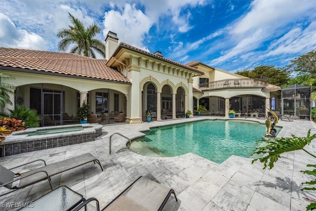 view of swimming pool featuring glass enclosure, a patio, and an in ground hot tub