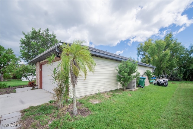 view of home's exterior featuring a garage, a yard, and central air condition unit