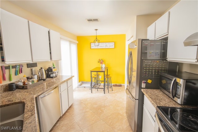 kitchen featuring white cabinets, sink, decorative light fixtures, stainless steel appliances, and light stone countertops