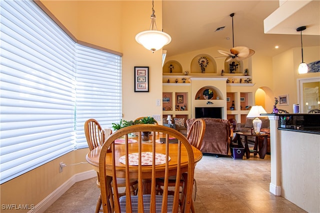 dining room featuring built in shelves, ceiling fan, a wealth of natural light, and vaulted ceiling