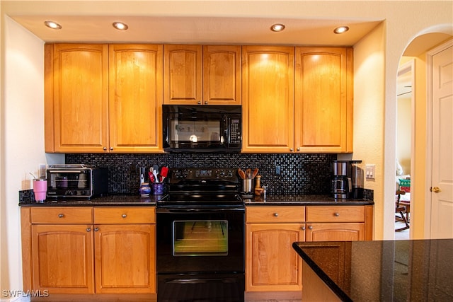 kitchen featuring dark stone counters, decorative backsplash, and black appliances