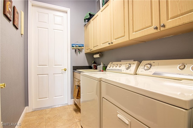 clothes washing area featuring cabinets, light tile patterned floors, sink, and washing machine and dryer