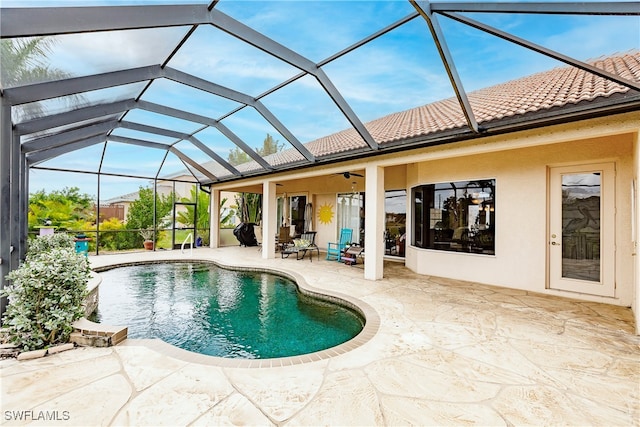 view of pool with ceiling fan, a patio, and glass enclosure