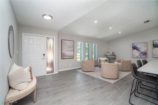 living room with vaulted ceiling and wood-type flooring