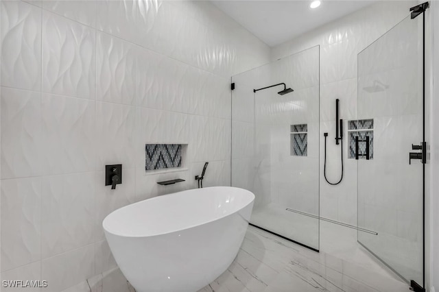 bathroom with tile walls and independent shower and bath