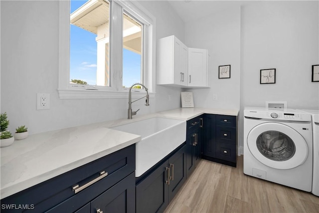 washroom featuring cabinets, light hardwood / wood-style floors, washer / dryer, and sink