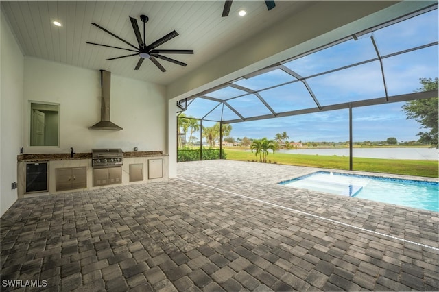 view of patio featuring a lanai, area for grilling, ceiling fan, and a water view