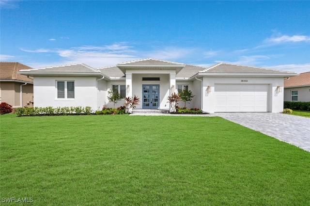 view of front facade with a garage, a front yard, and french doors