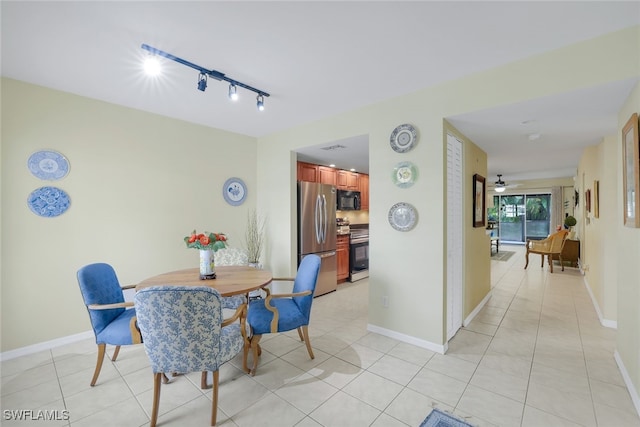 tiled dining area with track lighting and ceiling fan