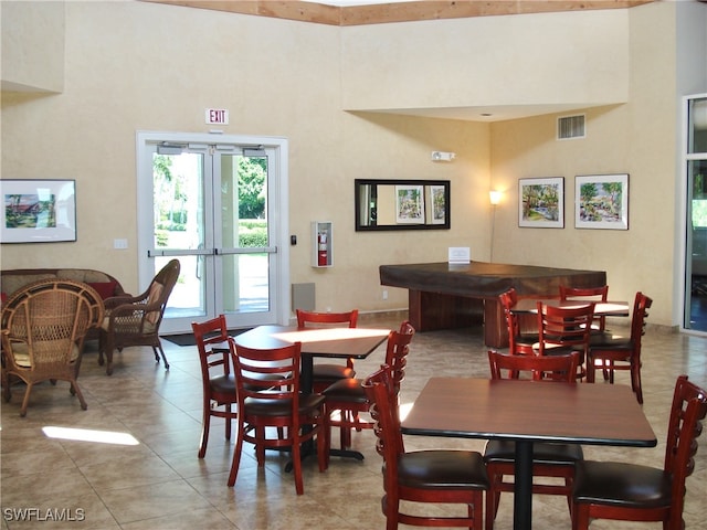 tiled dining room with a high ceiling