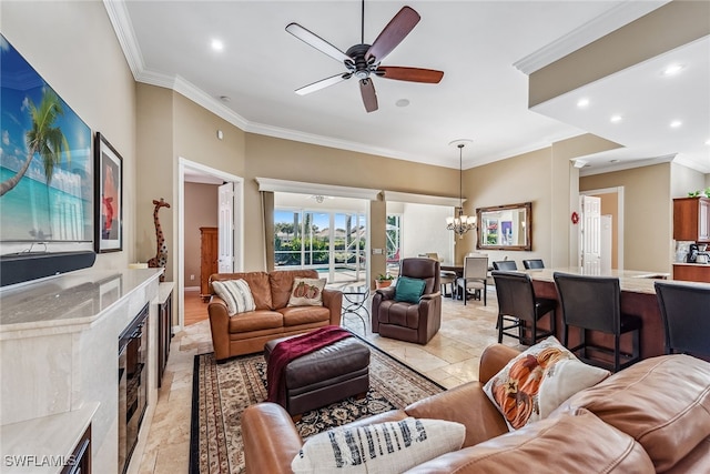 living room featuring ornamental molding, a premium fireplace, and ceiling fan with notable chandelier