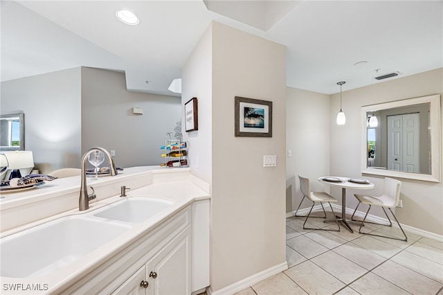 kitchen with white cabinets, light tile patterned floors, hanging light fixtures, and sink