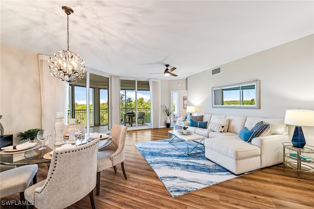 living room with hardwood / wood-style floors, ceiling fan with notable chandelier, and a wealth of natural light