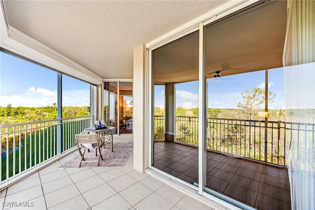 unfurnished sunroom with ceiling fan and a healthy amount of sunlight