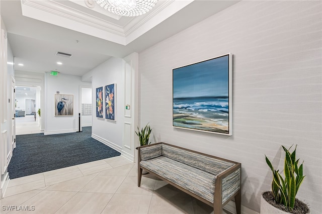 hallway featuring a raised ceiling, crown molding, and light carpet