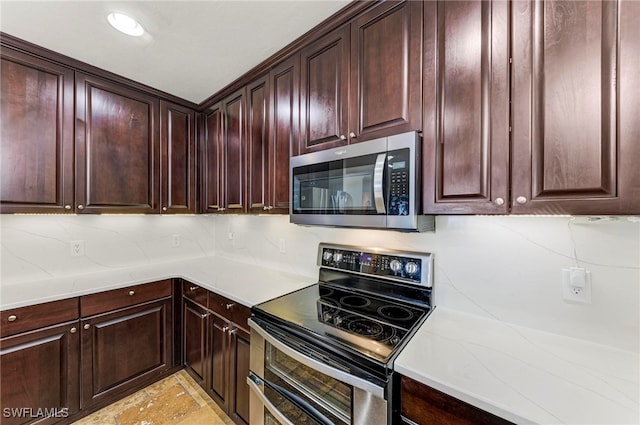 kitchen featuring dark brown cabinetry, appliances with stainless steel finishes, and tasteful backsplash