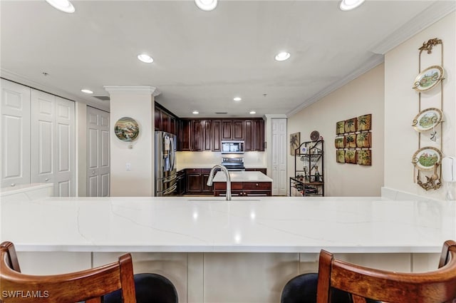 kitchen featuring appliances with stainless steel finishes, light stone counters, kitchen peninsula, crown molding, and sink