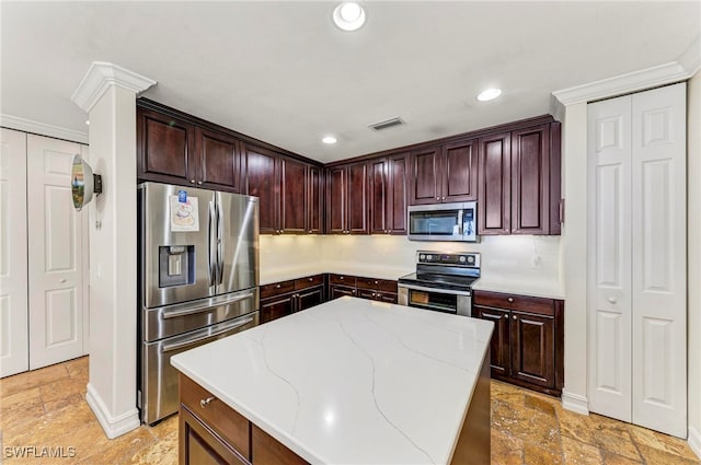 kitchen with light stone countertops, stainless steel appliances, tasteful backsplash, and a center island