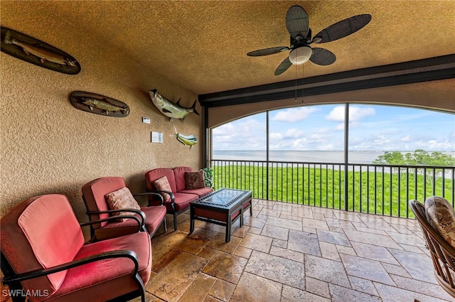 view of patio / terrace with ceiling fan, an outdoor hangout area, and a water view