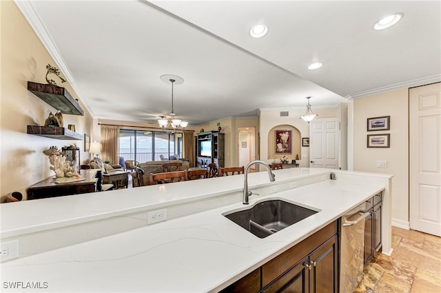 kitchen featuring light stone countertops, crown molding, decorative light fixtures, stainless steel dishwasher, and sink