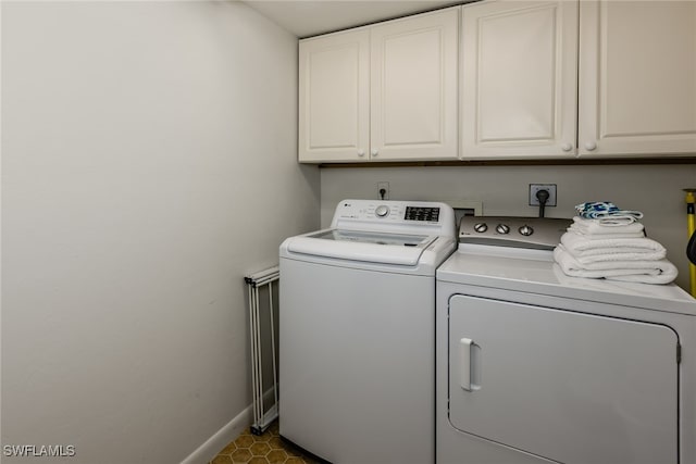 washroom featuring cabinets and washing machine and clothes dryer