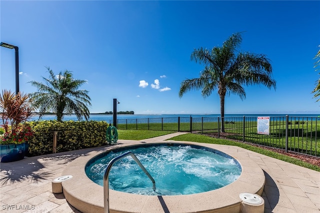 view of swimming pool with a lawn, a water view, and a community hot tub