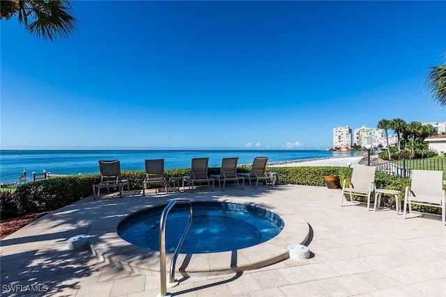 view of swimming pool featuring a water view, a patio area, and a community hot tub