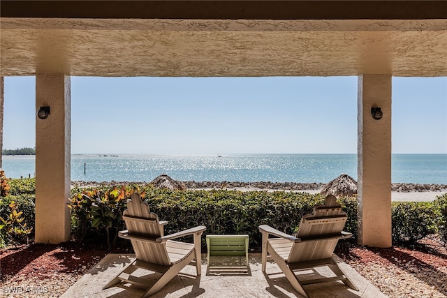 view of patio with a view of the beach and a water view