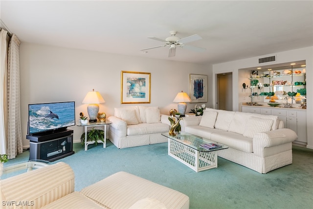 living room featuring ceiling fan, sink, and carpet flooring