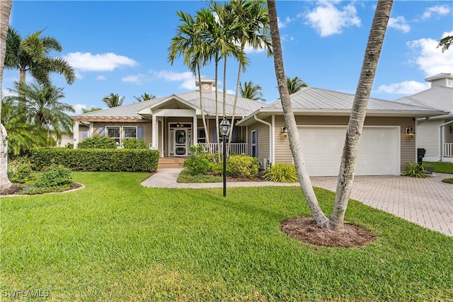 ranch-style home with a garage, a front lawn, and a porch