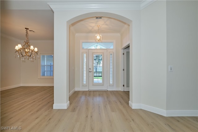 entrance foyer featuring light hardwood / wood-style floors, crown molding, and an inviting chandelier