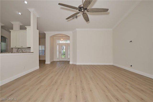 unfurnished living room with ceiling fan, ornamental molding, and light hardwood / wood-style flooring