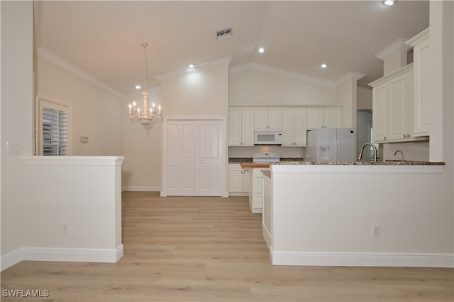 kitchen with white appliances, white cabinetry, pendant lighting, crown molding, and light hardwood / wood-style flooring