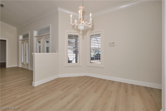 empty room with crown molding, a notable chandelier, and light wood-type flooring