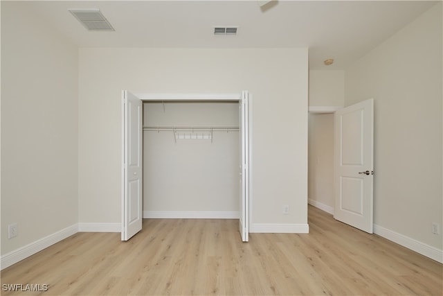 unfurnished bedroom with a closet and light hardwood / wood-style floors