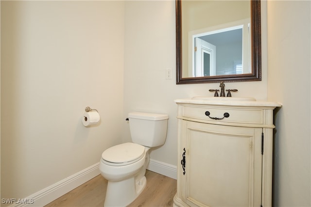 bathroom featuring toilet, hardwood / wood-style flooring, and vanity