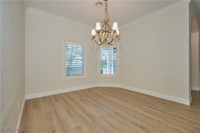 empty room featuring a notable chandelier, light hardwood / wood-style floors, and crown molding