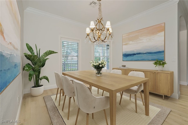 dining area featuring light hardwood / wood-style floors, crown molding, and a chandelier