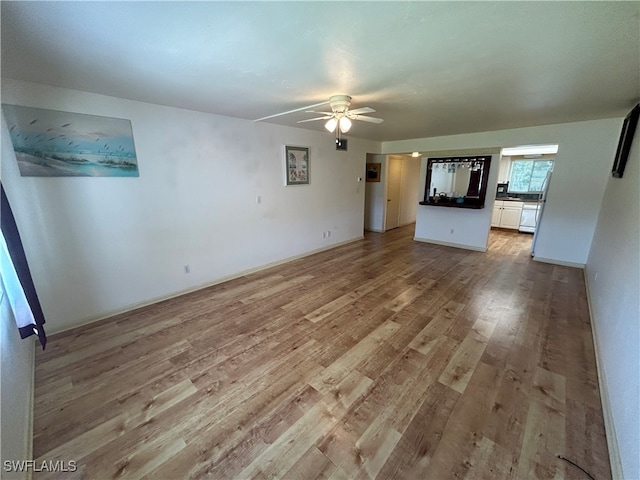 unfurnished living room with ceiling fan and light hardwood / wood-style flooring