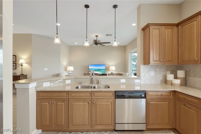 kitchen with light stone countertops, dishwasher, decorative light fixtures, and sink