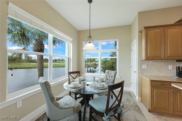 dining room with a water view and light tile patterned flooring