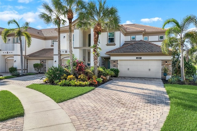 view of front of home with a balcony, a front lawn, and a garage