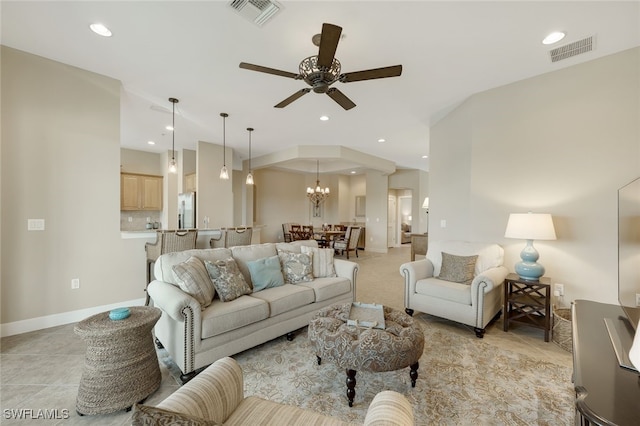 living room featuring ceiling fan with notable chandelier and light tile patterned flooring