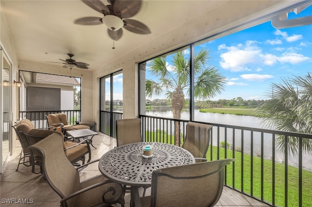 sunroom / solarium with a water view and ceiling fan